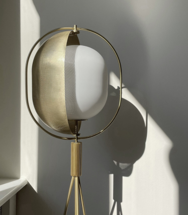 Skulpturálna stojacia lampa 101 Copenhagen s mosadznými detailmi a atmosférickou hrou svetla.