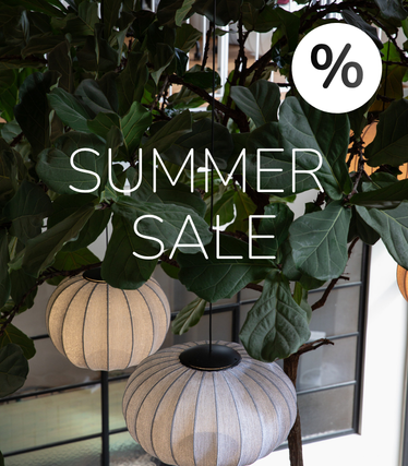 Látkové závesné svietidlá na pozadí bujnej zelene s oznámením Summer Sale.