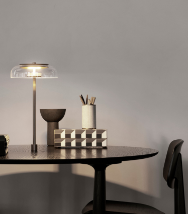 Elegantná stolná lampa na modernom pracovnom stole so štýlovými bytovými doplnkami.